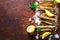 Bundle, bunch of fresh razor clams on ice, dark concrete background, lemon, herbs. Copy space, top view.