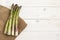 A bundle of cultivated asparagus on white wooden table.