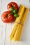 Bundle of dried spaghetti with basil and tomatoes