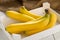 Bundle of fresh, yellow, ripe bananas in box