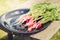 bundle healthy radish/ radish in a black bowl on a white bench in a garden, selective focus