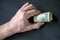 Bundle of rolled up dollar bills clutched in caucasian man`s hand. Male holding cash money currency of United States