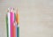 Bundle of wooden pencils in different color on a wooden background with free copy space for text