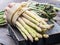 Bundles of green and white asparagus on wooden board. Organic food.