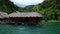 Bungalow on the water with a thatched roof on the lake.