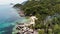 Bungalows and green coconut palms on tropical beach. Cottages on sandy shore of diving and snorkeling resort on Koh Tao paradise