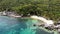 Bungalows and green coconut palms on tropical beach. Cottages on sandy shore of diving and snorkeling resort on Koh Tao paradise