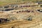 Bunk wall surface mine with exposed colored minerals and brown coal, the pit mining equipment