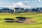 Bunker and fairway of a golf course with mountain and homes in the background