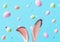 Bunny Ears with Floating Pastel Easter Eggs and Confetti on Blue Background