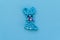Bunny made of beads, children`s crafts on a blue background