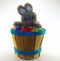 Bunny rabbit sitting on assorted easter eggs on wooden bucket