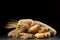 Buns, baguette, ciabatta and bread on dark wooden table. Rye, barley, wheat, oats and many fresh mixed breads on black ba