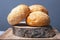 Buns for making burgers with sesame seeds on a wooden stand on a gray background close-up