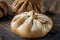 Buns of rye flour lie on a dark textured wooden background. Homemade cake. Mexican day of dead bread, pan de Muerto