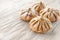 Buns of rye flour lie on a light wooden background. Mexican day of dead bread, pan de Muerto