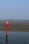 buoy in the tidal waddensea at low tide