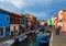 Burano island canal, small colored houses and the boats