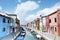 Burano island, Italy - beautiful view of a street with colorful houses and canal. Venice postcard