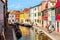 Burano island, Venice, Italy - September, 2017: Colorful houses in Burano near Venice, Italy with boats, canal and tourists.