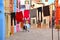 Burano, Italy. View of the colorful houses and courtyard with laundry cloths to dry outside and elderly woman relax o