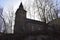 Burgbrohl, Germany - 02 23 2021: Alte Kirche between bold trees