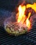 Burger barbecue being cooked on hot grill with smokey fire