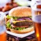 Burger with beer glasses and chicken wings