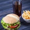 Burger drink and fries on a wooden table