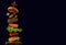 Burger with falling ingredients on a black background