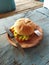 burger food stuffed with meat, cheese, onions, tomatoes, salad with a beachside cafe background