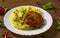 Burger with mashed potatoes in white plate on wooden background