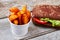 Burger near bucket with fries.