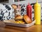 Burger on a tray with ketchup and mustard near a chocolate milkshake on a wooden table