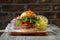 Burger on the wooden table with cheese, bacon, tomatos, green and red salad and french fries