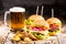 Burgers with beef and fried potatoes and glass of cold beer