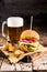 Burgers with beef and fried potatoes and glass of cold beer