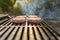 Burgers cooking over flames on grill - leisure, food and holidays concept