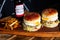 burgers, fries and beer on top of a wooden tray