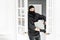 The burglar commits a crime in Luxury apartment with stucco. Thief with black balaclava stealing modern Electronic safe