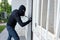 Burglar trying to force a door lock using a crowbar