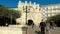 Burgos, Spain - October 18, 2022. Tourists walking through the arch of Santa Maria and medieval bridge in Burgos, Spain