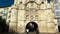 Burgos, Spain - October 18, 2022. Tourists walking through the arch of Santa Maria and medieval bridge in Burgos, Spain