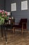 Burgundy armchair standing in dark living room interior with two