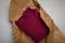 Burgundy cotton hoodie in natural paper package on white background. Eco-friendly product parcel wrapping. Care for environment