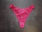 Burgundy crimson lace guipure thong for women on a black background