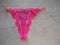 Burgundy crimson lace guipure thong for women on a gray background