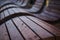 Burgundy or dark brown background with wavy lines. Urban architecture. Close up of curved modern bench