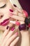 Burgundy multi-colored manicure and makeup .