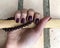Burgundy nail polish. Manicure on a female hand. Pomegranate nails